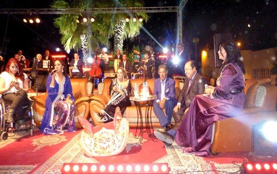 المحتفى به الفنان الدكالي يتوسط مجموعة من الفنانين