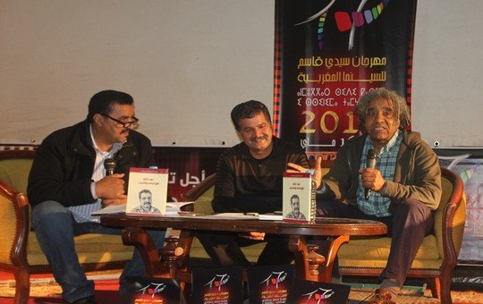 الناقد اتباتو يتوسط مخرجين سينمائيين بإحدى المهرجانات بسيدي قاسم