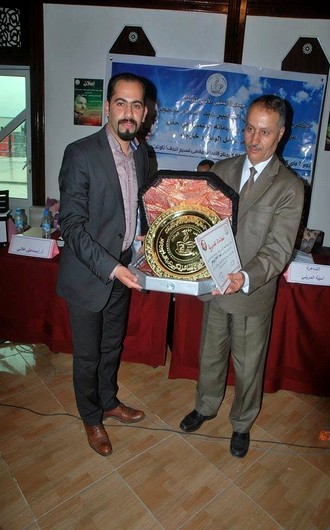 رئيس جمعية المقهى الأدبي يسلم هدية للشاعر بوحجر